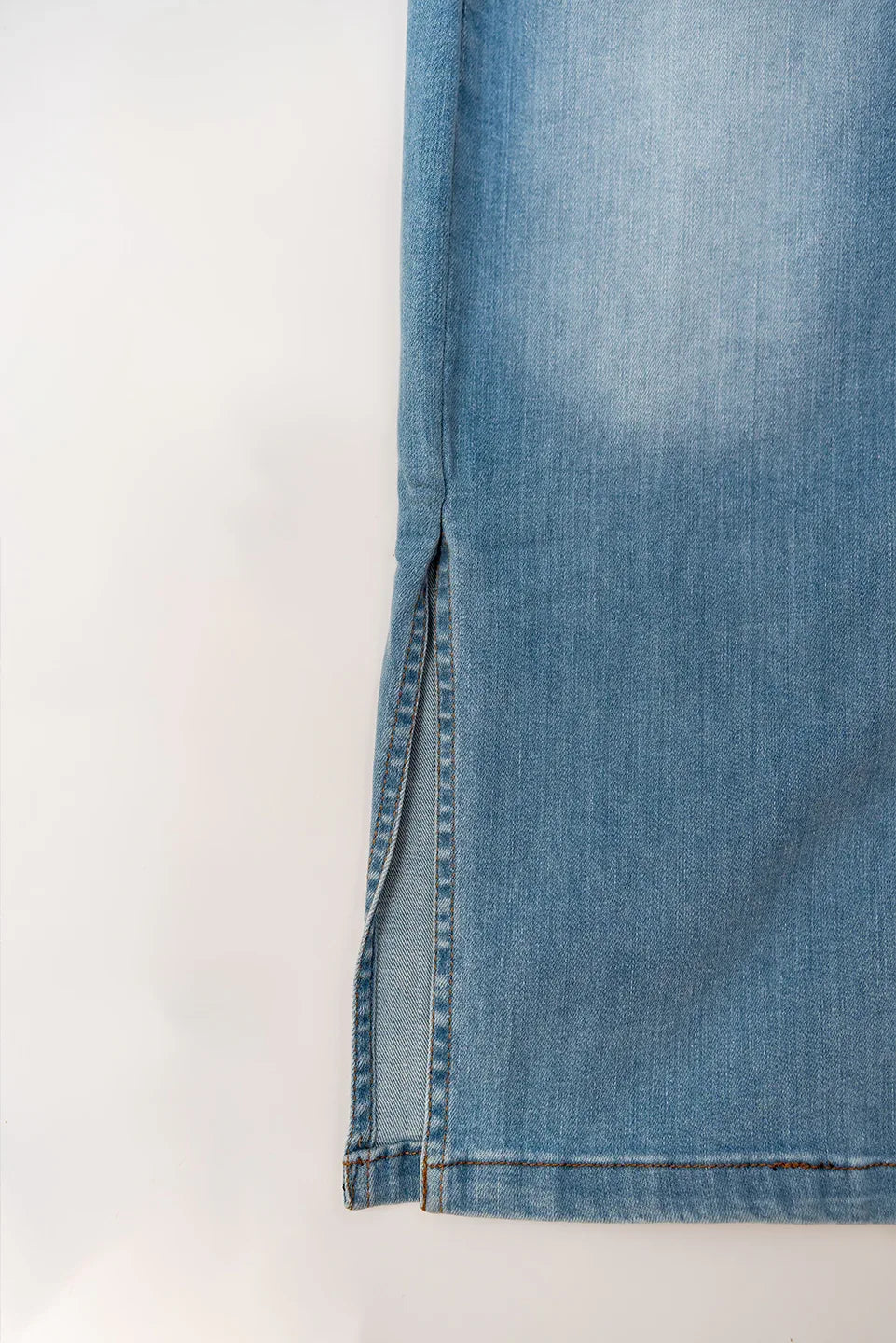 Side slit and hem detail of button down denim skirt