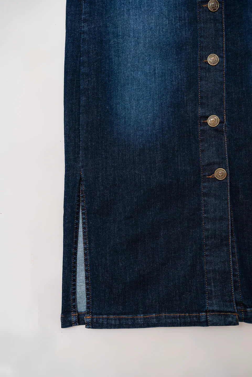 Back slit detail of blue button-down denim skirt, stitched hem of casual women’s fashion - verve